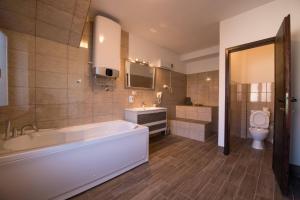 a bathroom with a tub and a sink and a toilet at Gardoš rooms in Zemun