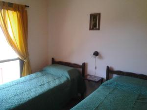 a bedroom with two beds and a window at Cabañas Lunas y Soles in Potrero de los Funes