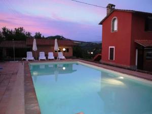 una piscina di fronte a una casa rossa di Self catering Villa with pool in Umbria, Italy a Todi
