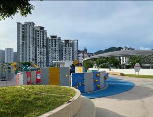 a playground in a park with buildings in the background at Spice Arena Guesthouse in Bayan Lepas