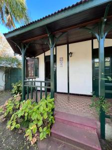 ein kleines Gebäude mit einer Veranda und einer Tür in der Unterkunft Villa Tamen - Colonia in Colonia del Sacramento