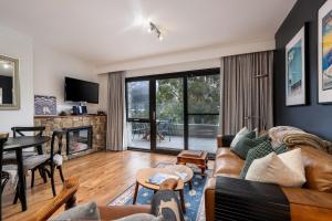 a living room with a couch and a fireplace at Lantern 1 Bedroom Deluxe with hot tub and car park in Thredbo