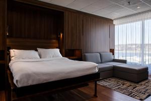 1 dormitorio con cama, sofá y ventana en Hotel Chicoutimi, en Saguenay