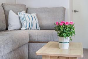 un jarrón de rosas rosas sentado en una mesa frente a un sofá en Maple Brook Lodge Sea Breeze Shorefield, en Lymington