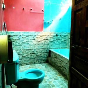 uma casa de banho com um WC azul e uma banheira em La Casona NiDo de ORO em Oropesa