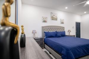 um quarto com uma cama azul e uma mesa em Serenity Haven - Your Ultimate Runaway Bay Escape em Runaway Bay