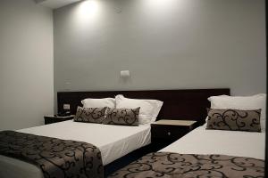 プラタモナスにあるZeus Hotelのホテルルーム 白いシーツ付きのベッド2台付