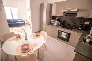 a kitchen with a white table and chairs in a room at Smart Appart - Commercants in Brussels