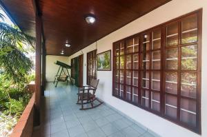 un porche de una casa con una silla y ventanas en Villa Jaco Sol, en Jacó