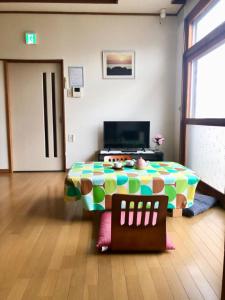 a room with a table and a television in it at Guest House Asahi in Otaru