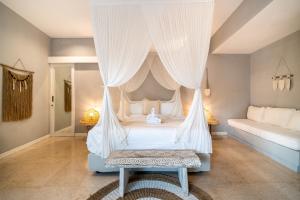 - une chambre avec un lit à baldaquin et des rideaux blancs dans l'établissement Villa Charles Ubud, à Ubud