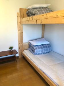two bunk beds in a room with a table at Guest House Asahi in Otaru