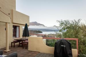 um pátio com uma mesa e um guarda-sol numa varanda em Magnificent Apartment with Great Views! em Queenstown