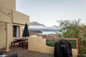a patio with a table and an umbrella on a balcony at Magnificent Apartment with Great Views! in Queenstown