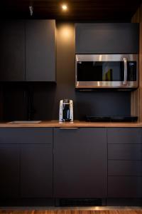 a kitchen with a counter with a microwave and a stove at Hotel Chicoutimi in Saguenay