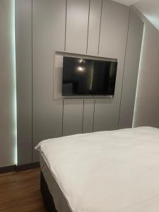 1 dormitorio con 1 cama y TV de pantalla plana en Uzunkum Hotel en Trebisonda