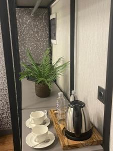 Uzunkum Hotel في طرابزون: غلاية الشاي على طاولة مع أكواب وصحون
