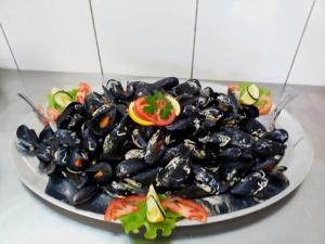 a plate of mussels with a tomato and salad at Rooms Ante in Tribanj-Krušćica