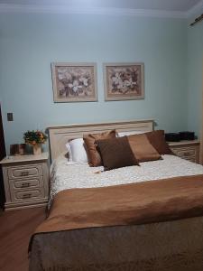 um quarto com uma cama grande e duas mesas de cabeceira em Espaço Aconchego em Uberaba