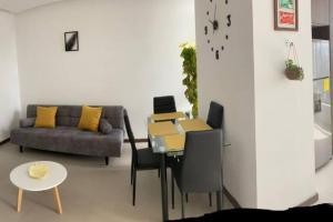 a living room with a table and a couch at Confort suite La Carolina in Quito