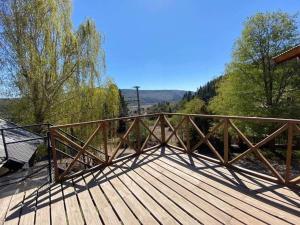 un puente de madera con un banco en una terraza de madera en La Casa de Belen en San Martín de los Andes