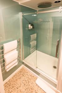a shower with a glass door and towels in a bathroom at Magnificent Apartment with Great Views! in Queenstown