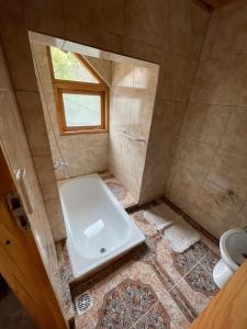 uma casa de banho com um chuveiro, um WC e um lavatório. em La Casa de Belen em San Martín de los Andes