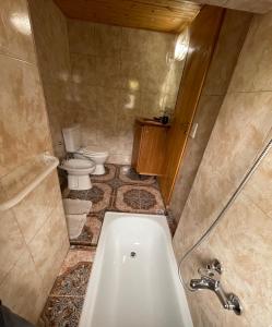 y baño con bañera y aseo. en La Casa de Belen en San Martín de los Andes
