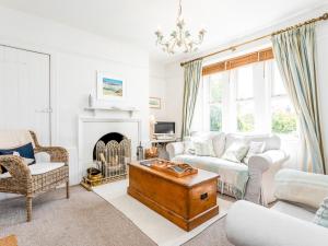 een woonkamer met een bank en een open haard bij Elliot Cottage in Bamburgh