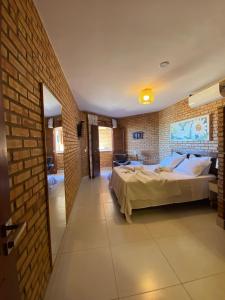 a bedroom with a bed and a brick wall at Pousada Casa Do Alemão in Flecheiras