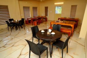 un ristorante con tavoli e sedie in una stanza di KOTTACKAL NATURE INN ad Angamaly