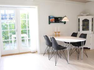 uma sala de jantar com uma mesa branca e cadeiras em Holiday home Svaneke II em Svaneke