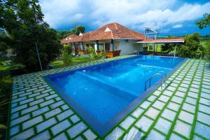 una piscina frente a una casa en KOTTACKAL NATURE INN, en Nedumbassery