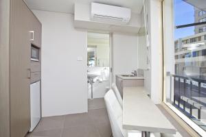 a kitchen with a white counter top and a white refrigerator at Manly Paradise Motel & Apartments in Sydney