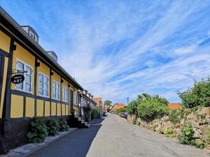 an empty street with a yellow building on the side at 6 person holiday home in Allinge in Allinge