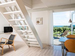 a white staircase in a living room with a table and chairs at 6 person holiday home in Allinge in Allinge