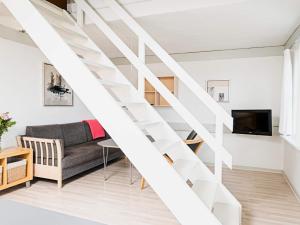 a white staircase in a living room with a couch at 6 person holiday home in Allinge in Allinge