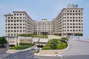 a large white building with a courtyard in front of it at E-DA Skylark Hotel in Dashu