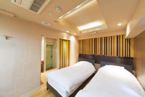 a bedroom with two beds and a ceiling at International Hotel Kabukicho in Tokyo