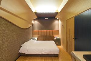 um quarto com uma cama branca num quarto em International Hotel Kabukicho em Tóquio