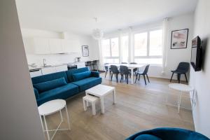 a living room with a blue couch and a table at TravelEase - Midi in Brussels