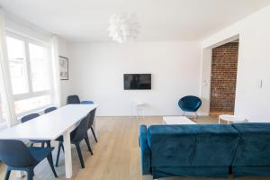 a living room with a table and a blue couch at Smart Appart - Clmenceau in Brussels