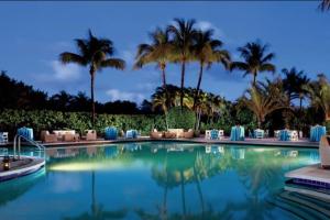 une piscine avec des palmiers en arrière-plan dans l'établissement Stunning Studio Apartment Located at the Ritz Carlton-Key Biscayne, à Miami