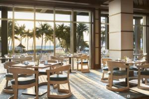 een restaurant met tafels, stoelen en ramen bij Stunning Studio Apartment Located at the Ritz Carlton-Key Biscayne in Miami