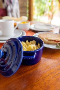 a blue bowl of food on a wooden table at Pousada NÔ Caraíva in Caraíva