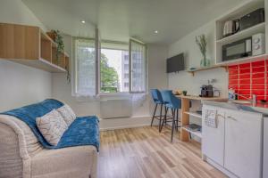 a living room with a couch and a kitchen at Le Taillefer 3 - Le Frenchi in Rhut