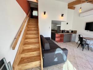 a living room with a couch and a staircase at Le Romulus in Roumoules