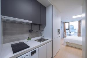 a kitchen with a sink and a bed in a room at Chuncheon Bella Residence in Chuncheon