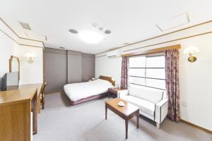 Pokój hotelowy z łóżkiem i biurkiem w obiekcie Shinjuku East Hotel w Tokio