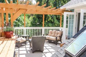 un patio con pérgola, mesa y sillas en Kelowna Bed & Breakfast - CHATHAM HOUSE, en Kelowna